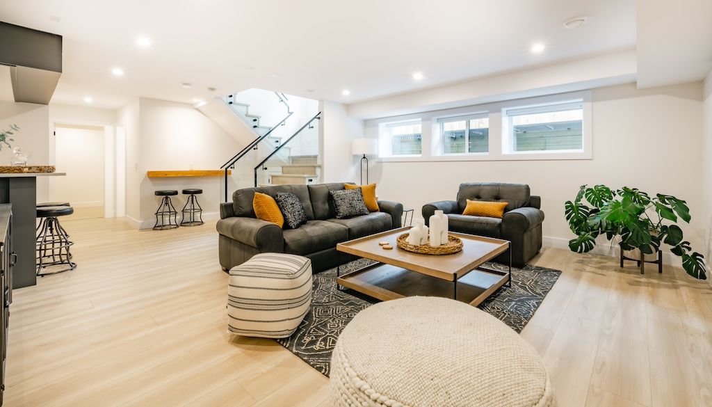 Open-concept basement finishing with recessed lighting and LVP flooring