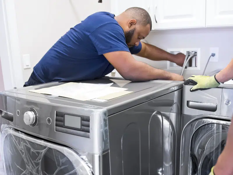 Professional appliance installation with new stainless steel dishwasher