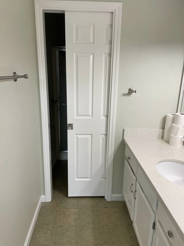 Bathroom remodel with new vanity, framed mirror, and pocket door