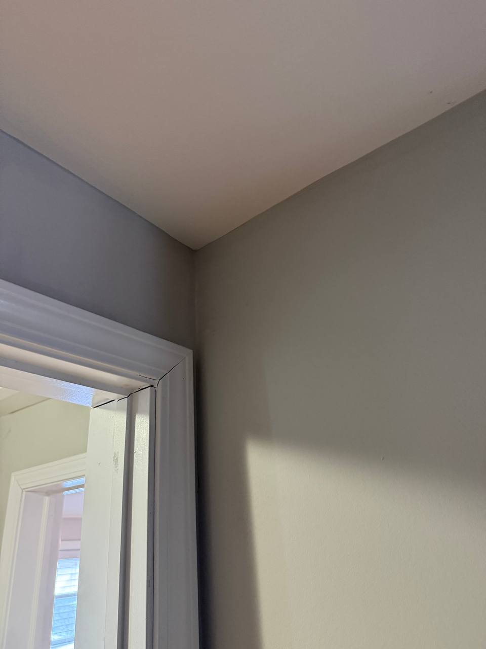 Drywall crack repair around door frame with mesh tape and compound