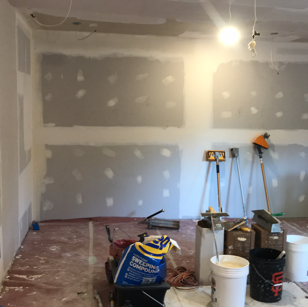 Fresh drywall installation with first coat of joint compound at seams