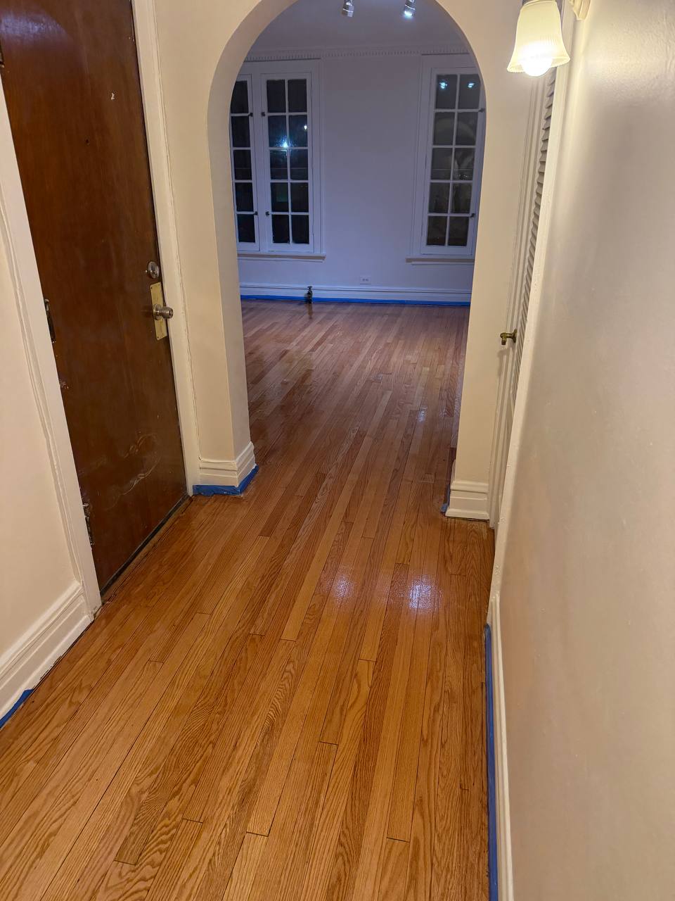 Hardwood floor refinishing showing rich natural wood grain after sanding and staining