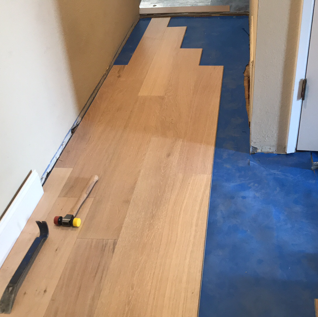 New hardwood flooring installation with tongue-and-groove oak planks